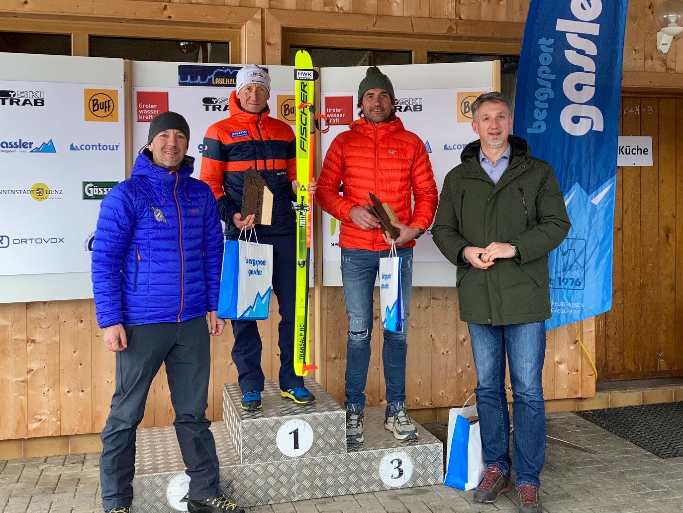 Tagesschnellster Christian Hoffmann am Siegespodest mit dem Drittplatzierten in der Senior-Klasse Manfred Dorfmann aus dem Ahrntal, li: Alpenraute-Obmann Stefan Stern, re: Bgm Markus Einhauer. Foto: Stangl