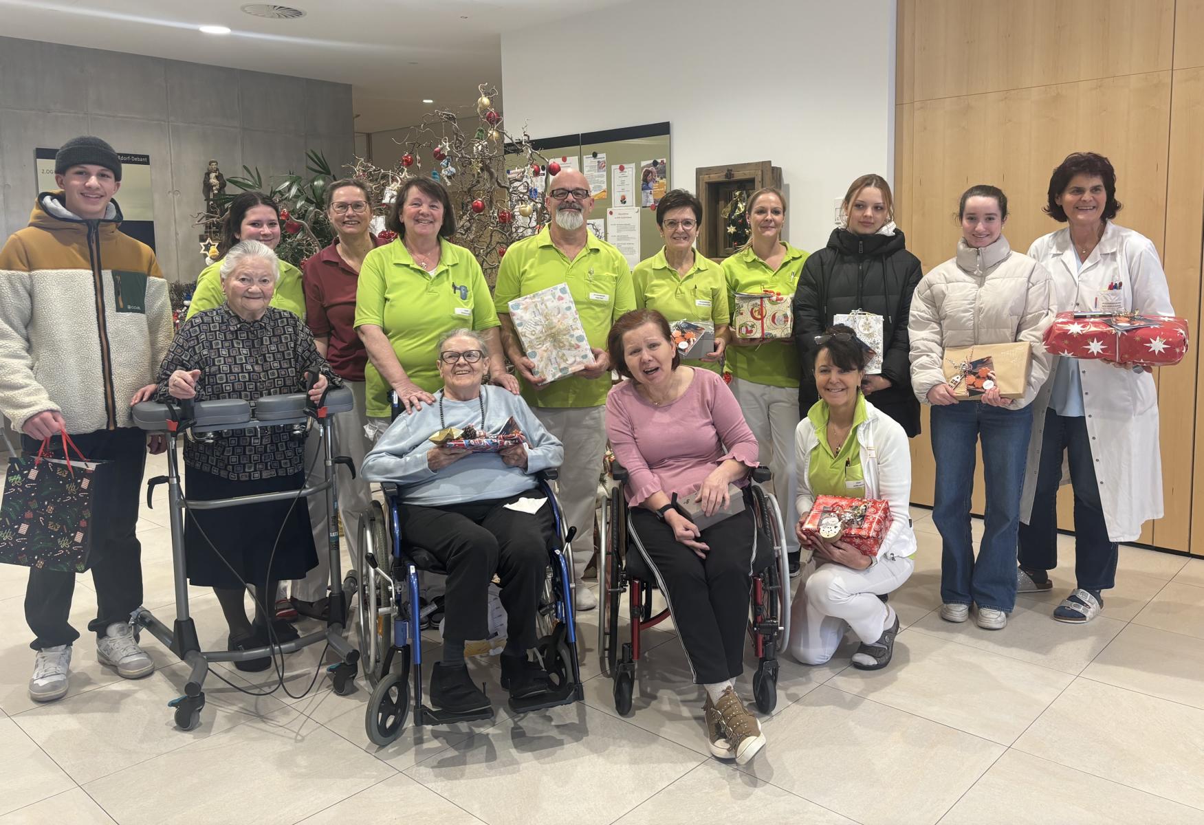 Bewohner:innen mit Personal samt Pflegedienstleitung Annemarie Klaunzer des WPH Nu&szlig;dorf-Debant und Sch&uuml;ler:innen der Fachschule f&uuml;r wirtschaftliche Berufe der Dominikanerinnen bei der Geschenke&uuml;bergabe. Foto: Regionsmanagement Osttirol FWZ