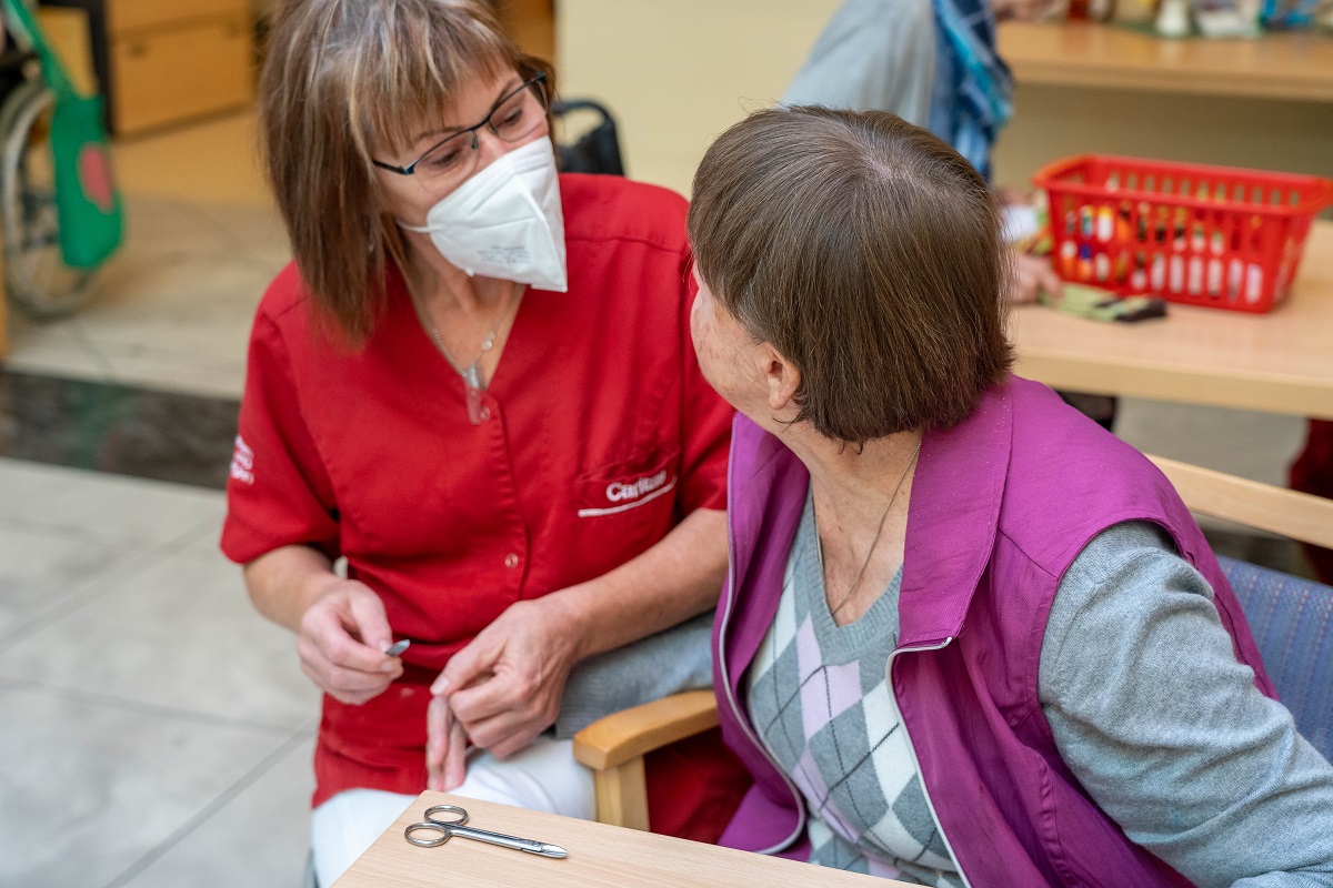Christa Berger bei der Nagelpflege mit Bewohnerin Maria Granig