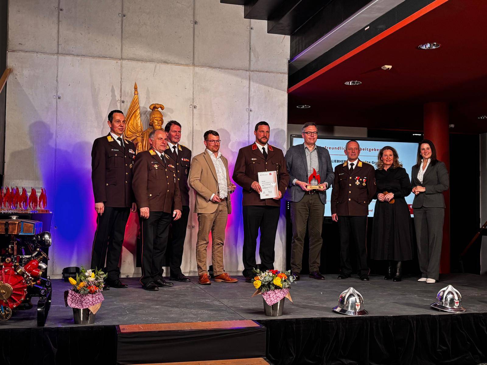 Die Liebherr Vertreter bei der Preisverleihung. (Bildmitte: Drexel Nikolaj (Kommandant-Stv der Betriebsfeuerwehr) links davon Christian Moser (Leitung Health, Safety & Environment) und rechts Holger K&ouml;nig (Gesch&auml;ftsf&uuml;hrer). Foto: Lintner
