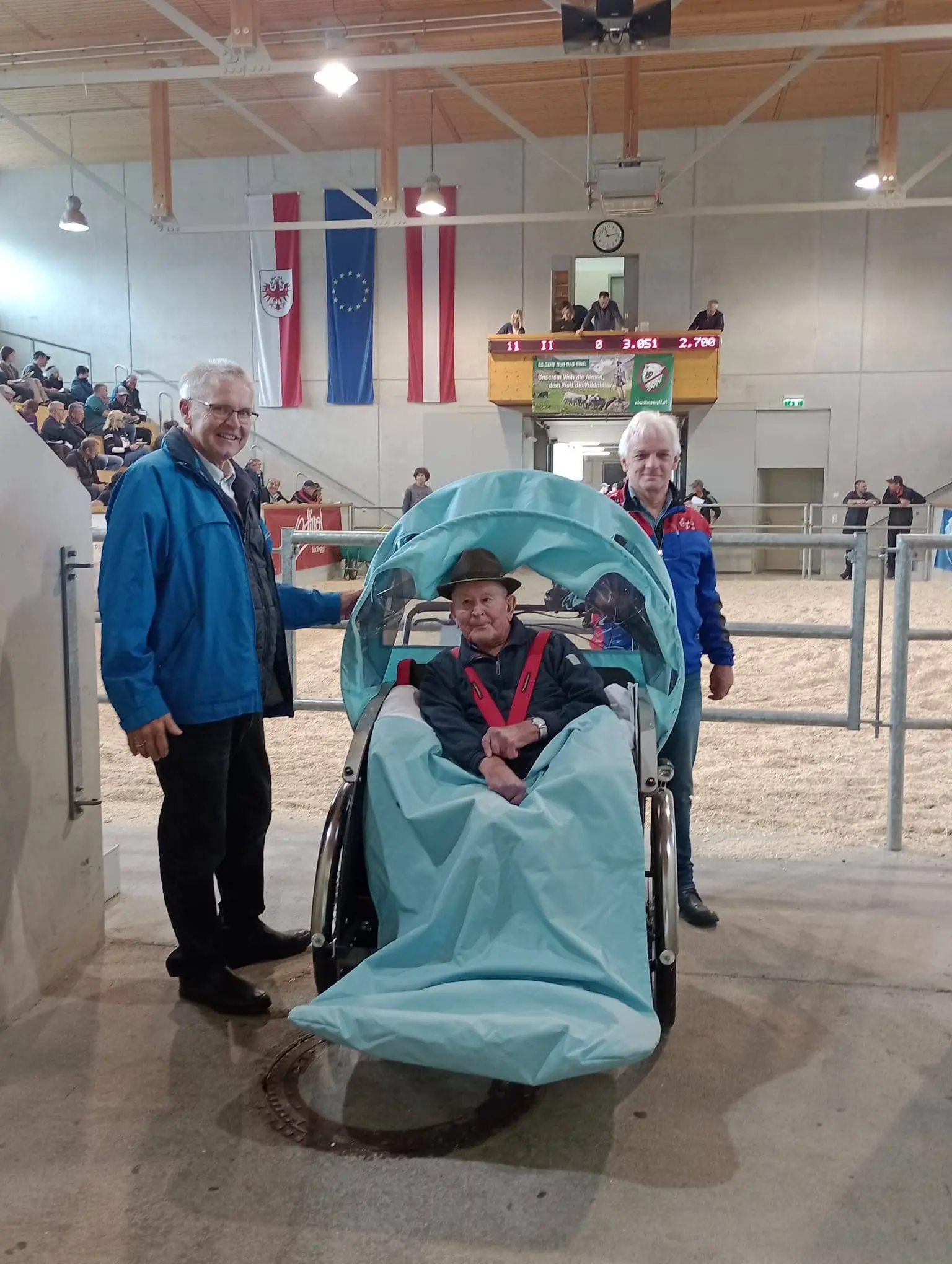 Herr Kollreider mit den Rikscha-Piloten Christian Pichler (l) und Karl Schlacher (r) bei einer Versteigerung in der RGO-Arena, Foto: RMO/FWZ