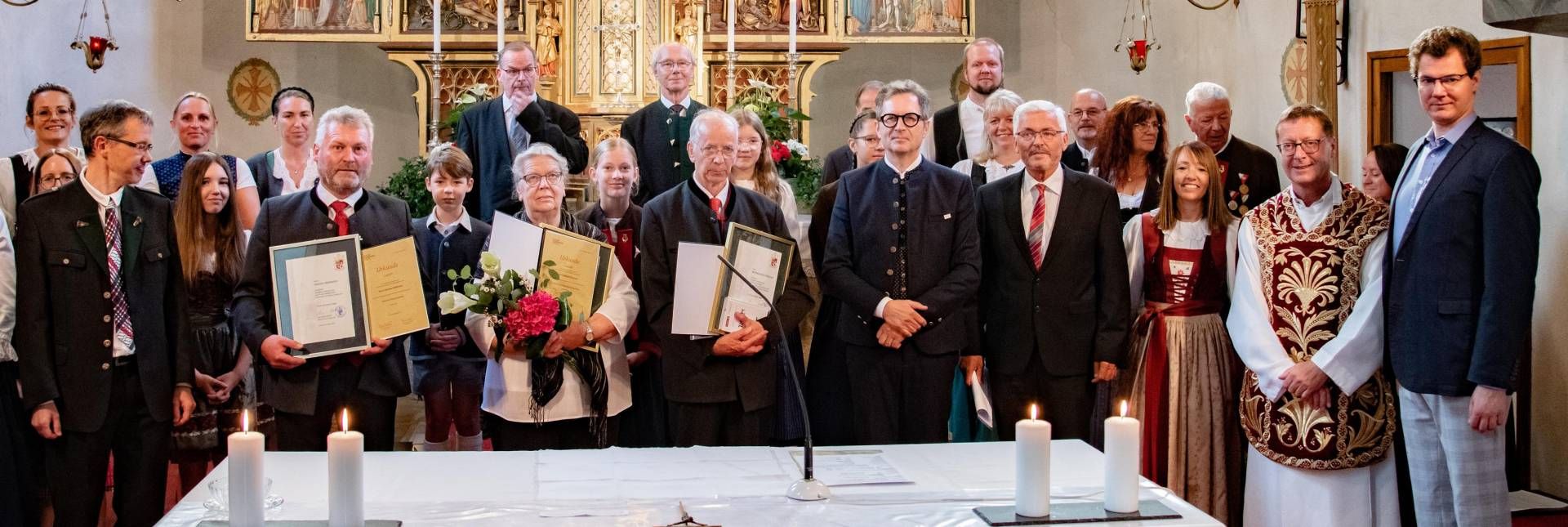 Die Geehrten: Hannes Webhofer, Elisabeth und Bartholom&auml;us Klaunzer (v.l.) mit Gernot Kacetl (Chorleiter, l.), Martin Waldauf (Obmann Chorverband Tirol), Georg Webhofer (Obmann), Herta Webhofer (Vorstandsmitglied), Dekan Franz Troyer, Manfred Novak (Kirchenmusikreferent, v.l.) mit einem Teil des Kirchenchors.