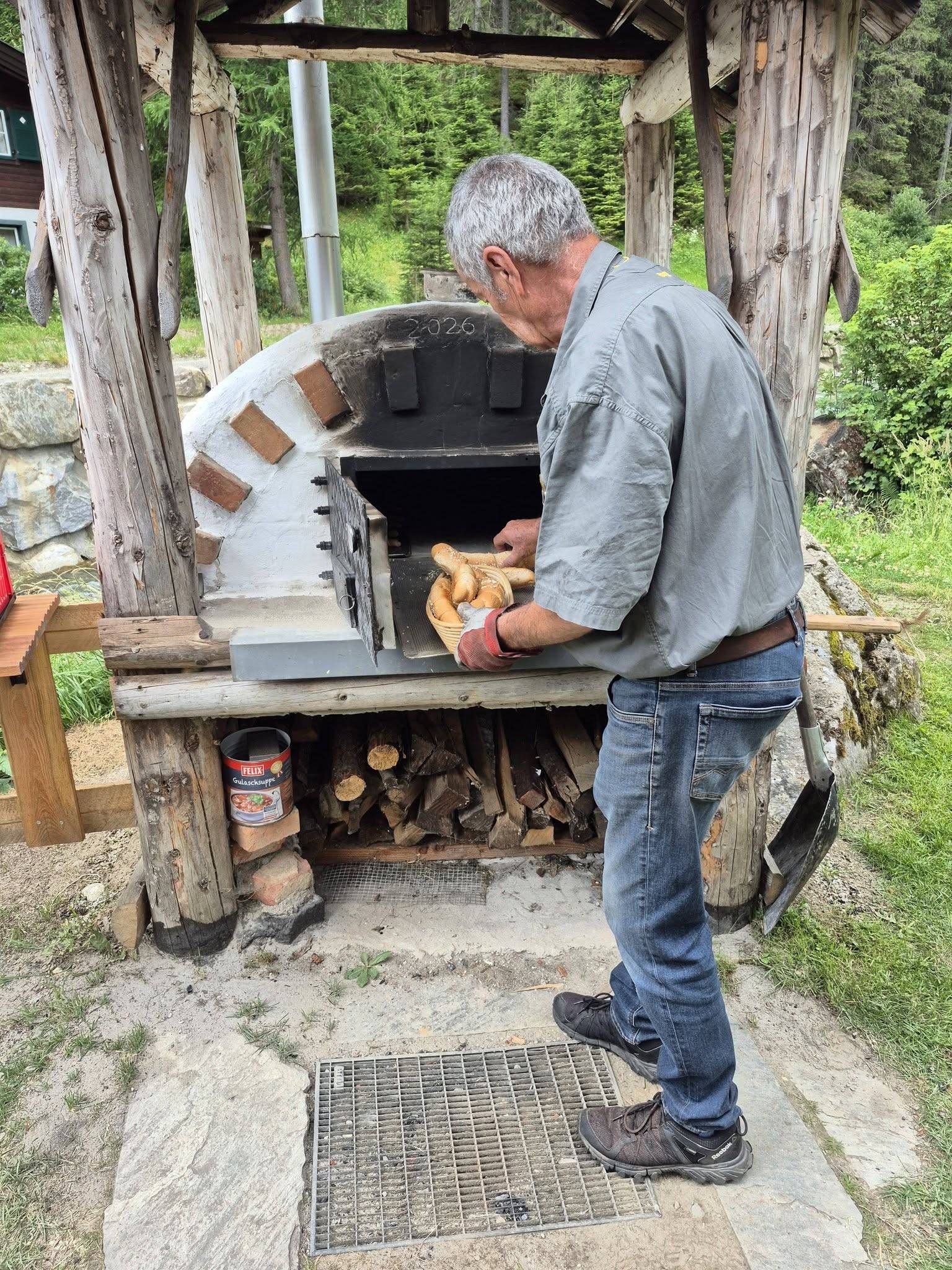 Hermann Unterrainer von der Initiative &bdquo;Belebung & Erhaltung Mallnitzer Stockm&uuml;hlen&ldquo; holte die ersten Brote aus dem neuen Holzbackofen.