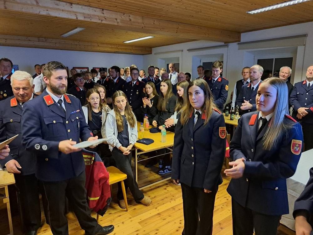 Kdt.-Stv. Michael Unterwalcher gratuliert Sara Pichler und Jana Lena Auer zur Aufnahme in den Aktivstand der Feuerwehr.