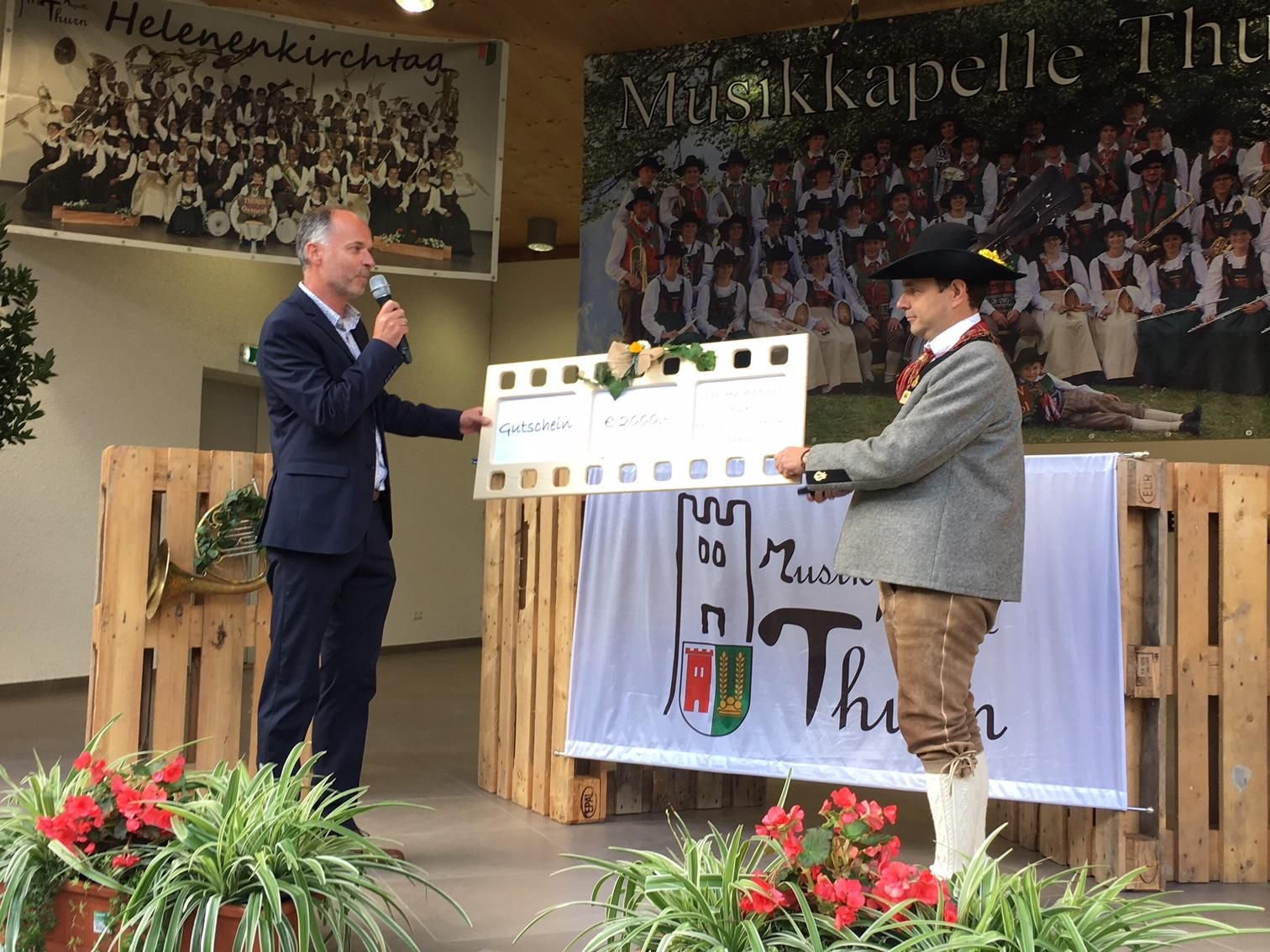 B&uuml;rgermeister Reinhold Kollnig &uuml;ber Scheck in H&ouml;he von 2000 Euro f&uuml;r Instrumentenankauf an Obmann Johannes Nemmert, Foto: Stangl