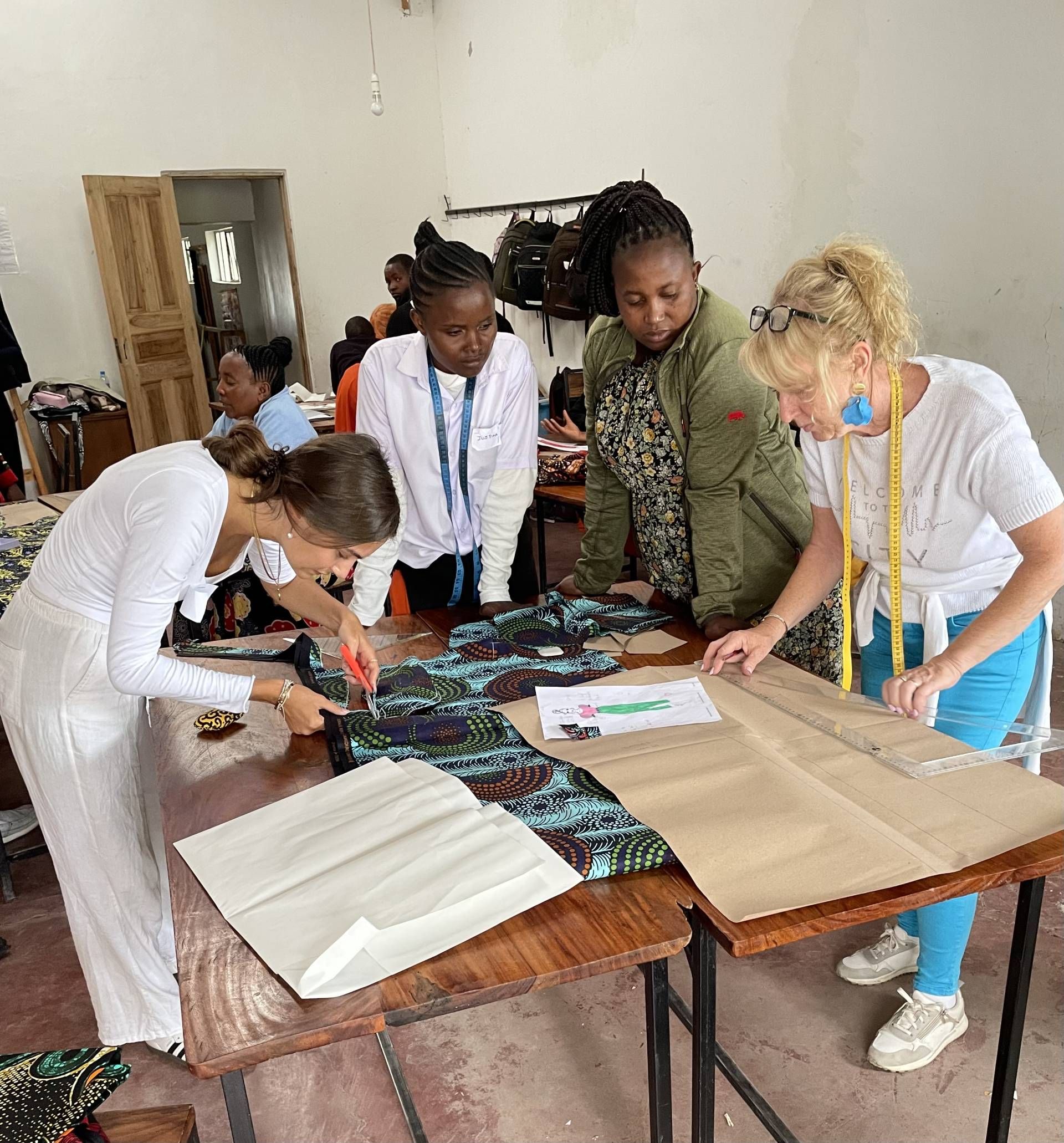 Sch&uuml;lerin Lisa Sadek und die WIMO-Lehrerin Erika Schranz mit Sch&uuml;lerinnen der &bdquo;Tailoring School Africa Amini&ldquo;. Fotos: privat