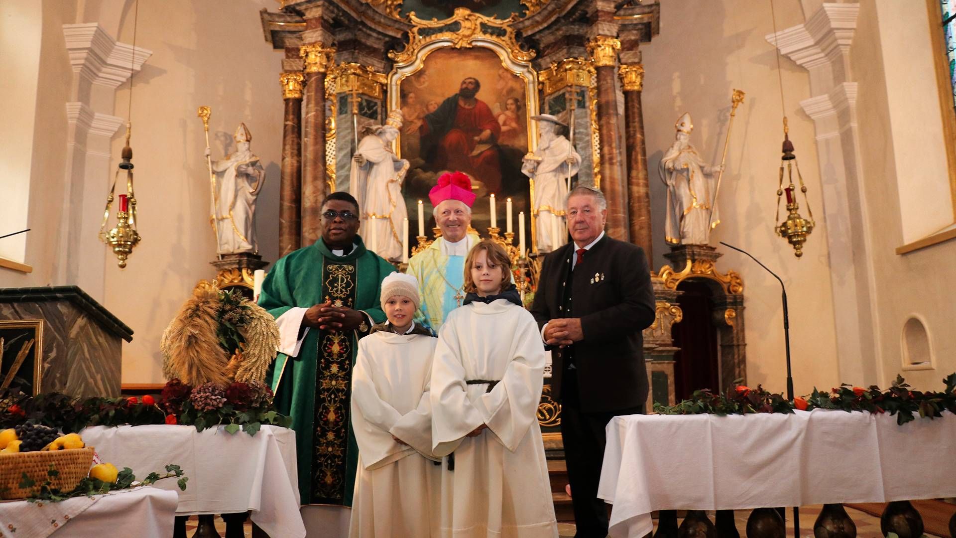 Pfarrer Sergius Duru, Msgr. Domprobst Engelbert Guggenberger und PGR-Altobmann Albert Schellander sen. mit den beiden Ministranten... und ...